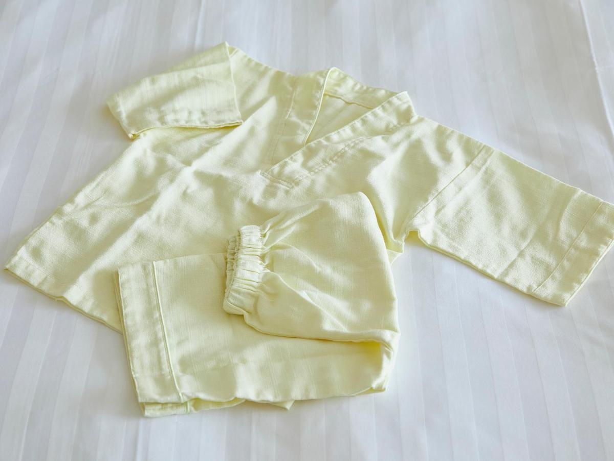 Grand Nikko Tokyo Bay Maihama Hotel Urayasu Exterior foto The photo shows a small, traditional outfit made of light yellow fabric. The outfit includes a short-sleeved top with a V-neck and a pair of matching pants. The design is simple, featuring a loose fit and a comfortable style, making it suitable for c