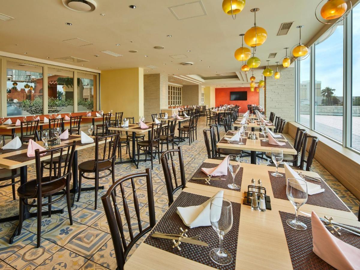 Grand Nikko Tokyo Bay Maihama Hotel Urayasu Exterior foto The photo shows a spacious restaurant interior with multiple wooden tables arranged neatly. Each table is set with plates, glasses, and folded napkins, suggesting it's prepared for dining. The decor features large windows allowing natural light to fl