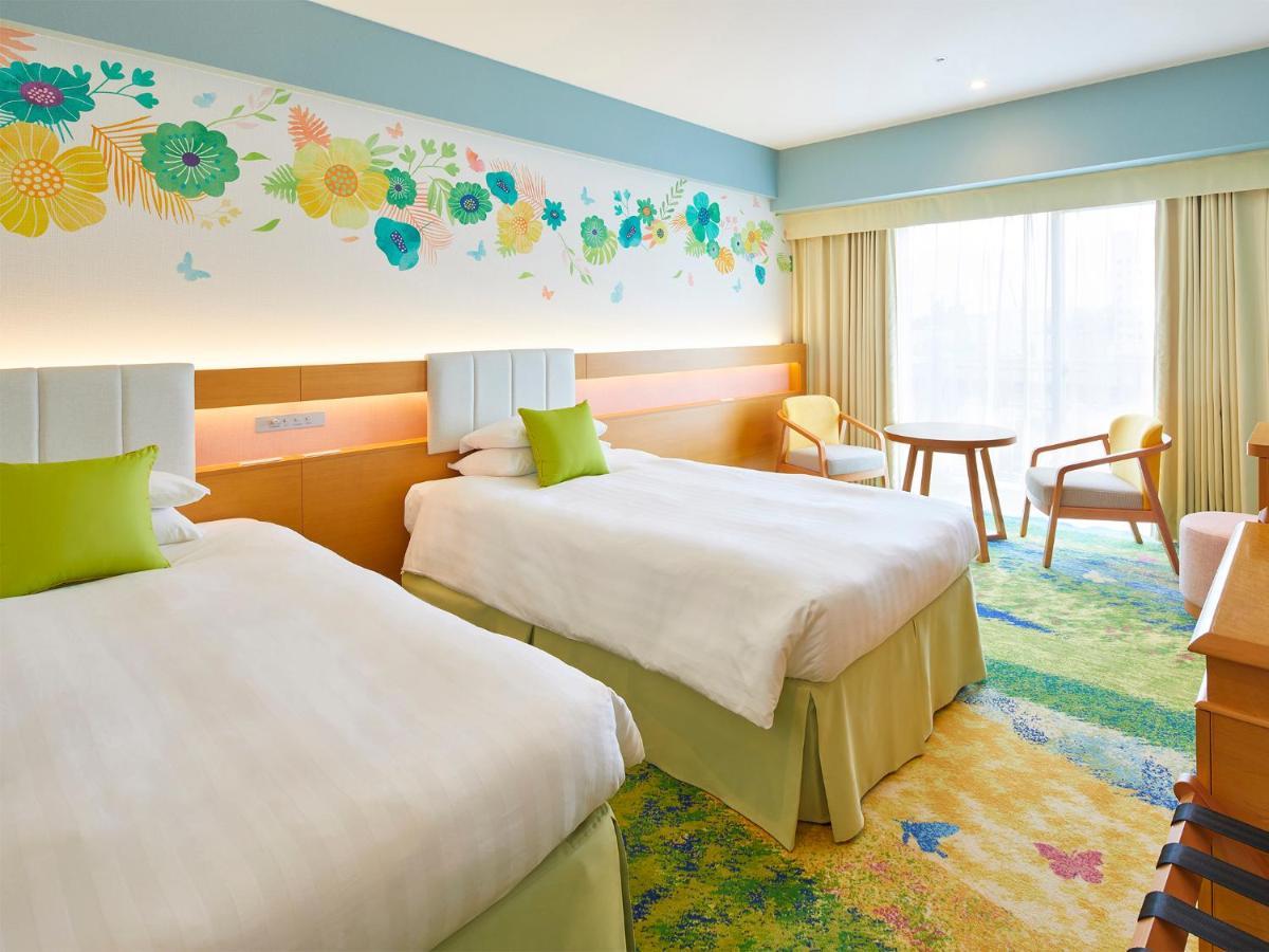 Grand Nikko Tokyo Bay Maihama Hotel Urayasu Exterior foto The photo shows a brightly decorated hotel room featuring two twin beds with white linens and light green accents. Above the beds is a colorful floral mural that adds a cheerful touch to the space. There is a small table and chairs by the window, whi