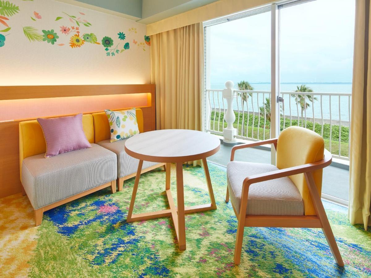 Grand Nikko Tokyo Bay Maihama Hotel Urayasu Exterior foto The photo shows a cozy interior space, likely a hotel room or a lounge area. It features a small round table in the center surrounded by comfortable seating. There are two chairs: one is a light wooden frame with a yellow seat, and the other has a mo