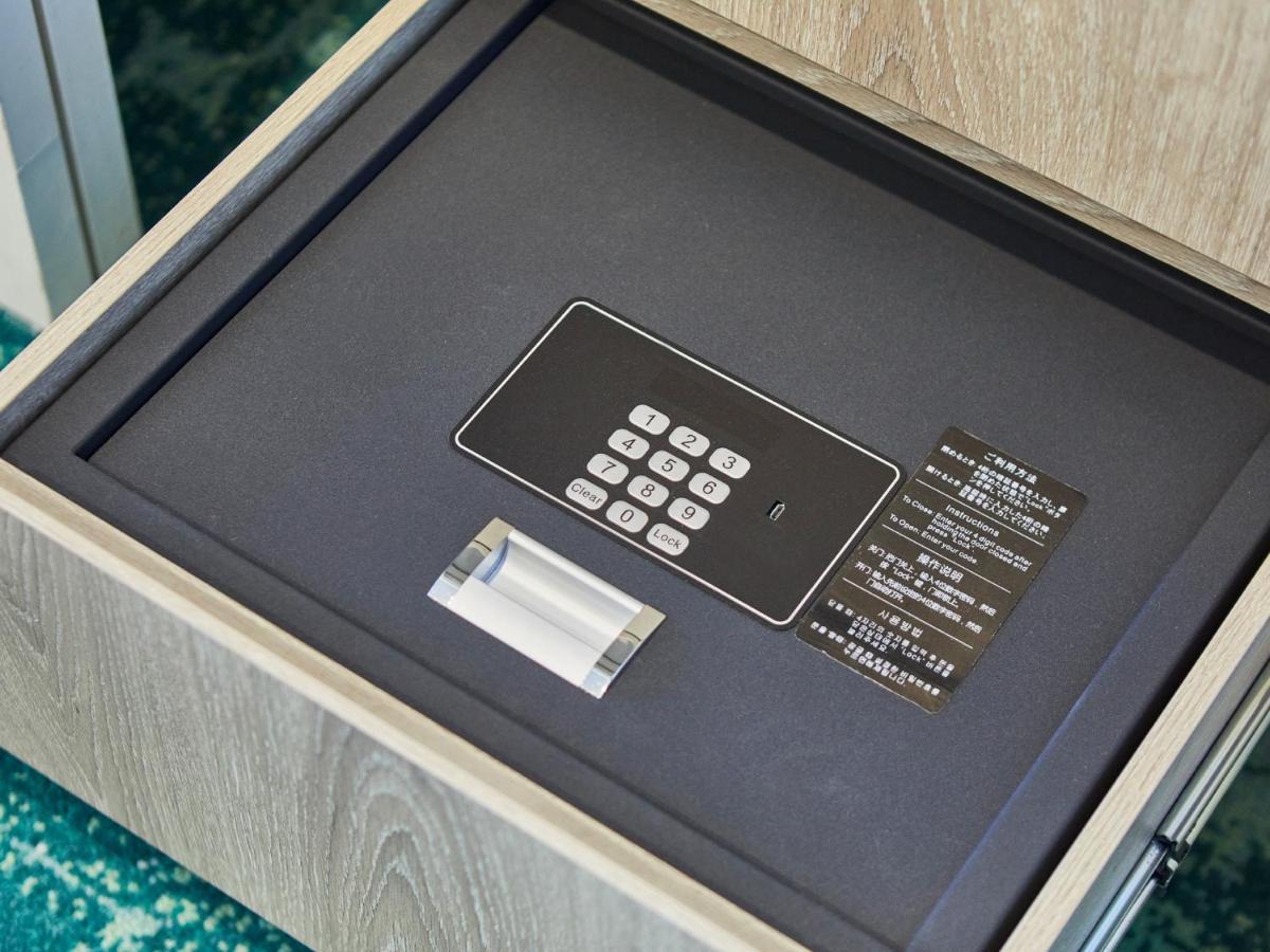 Grand Nikko Tokyo Bay Maihama Hotel Urayasu Exterior foto The photo shows a small safe that is installed in a drawer. Inside the safe, there is a digital keypad with numeric buttons for entering a code. Next to the keypad, there appears to be a small manual or instruction card. The interior of the safe is l