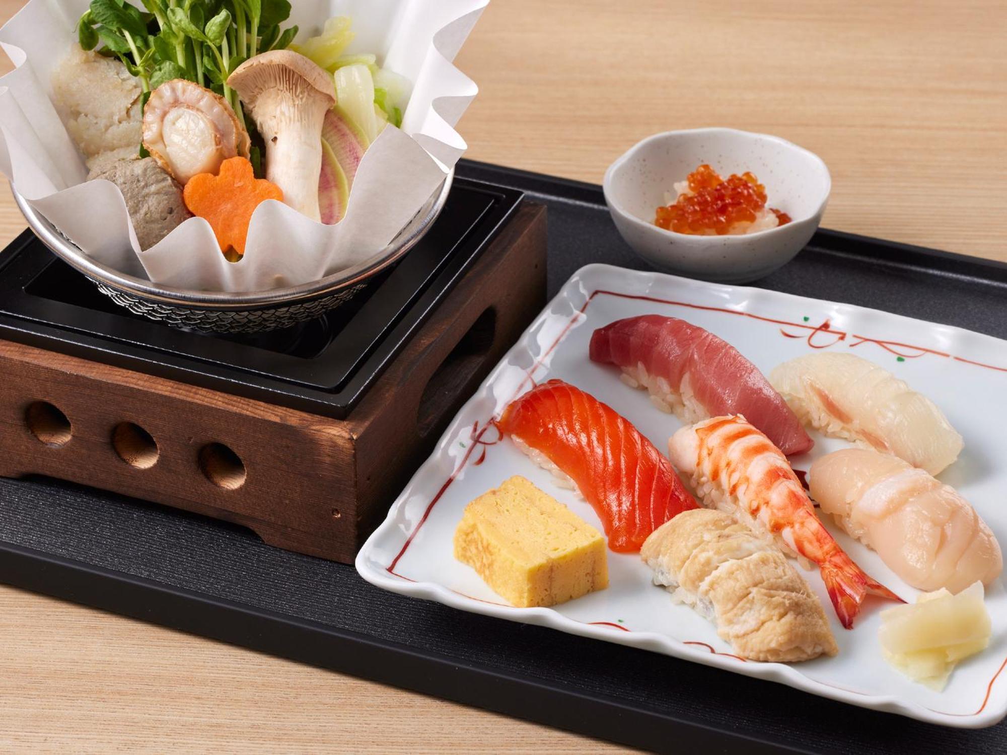 Grand Nikko Tokyo Bay Maihama Hotel Urayasu Exterior foto The photo features a Japanese meal presented on a wooden tray. On the left, there is a small pot with a clear broth containing vegetables, mushrooms, and possibly meat, indicated by green herbs and a piece shaped like a flower. On the right, there is